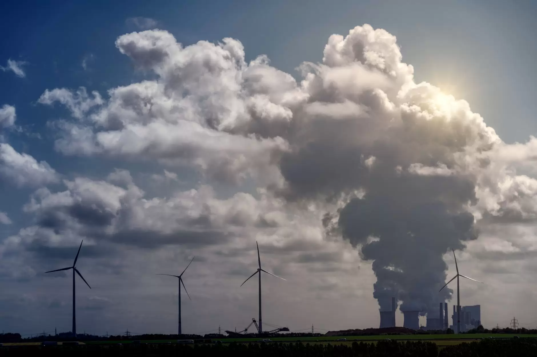 Levelized Cost of Electricity: What It Captures and What It Leaves Out — gas turbine power plant and wind turbines side by side