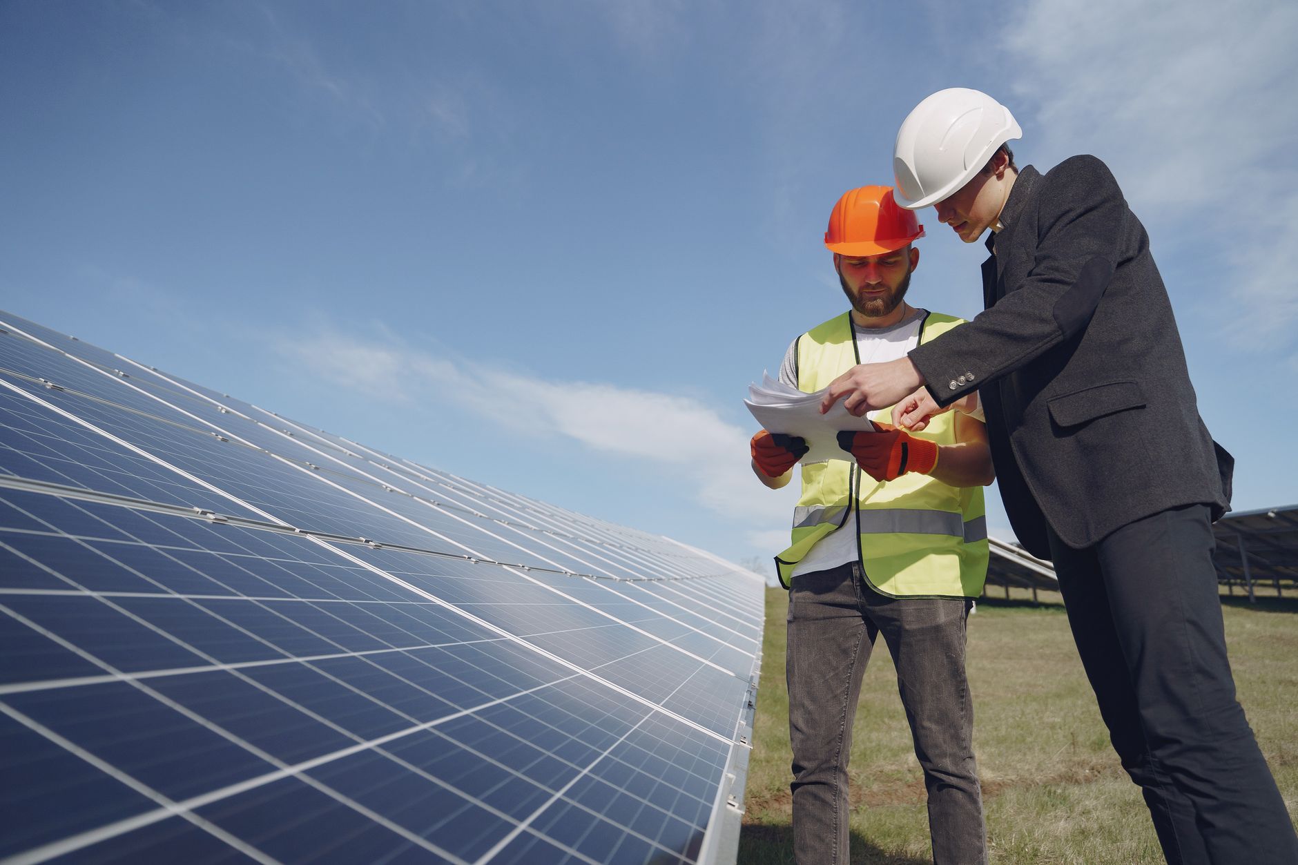 Merchant Risk and the Rise of Corporate PPAs in Renewable Finance — business handshake in front of solar panels renewable energy