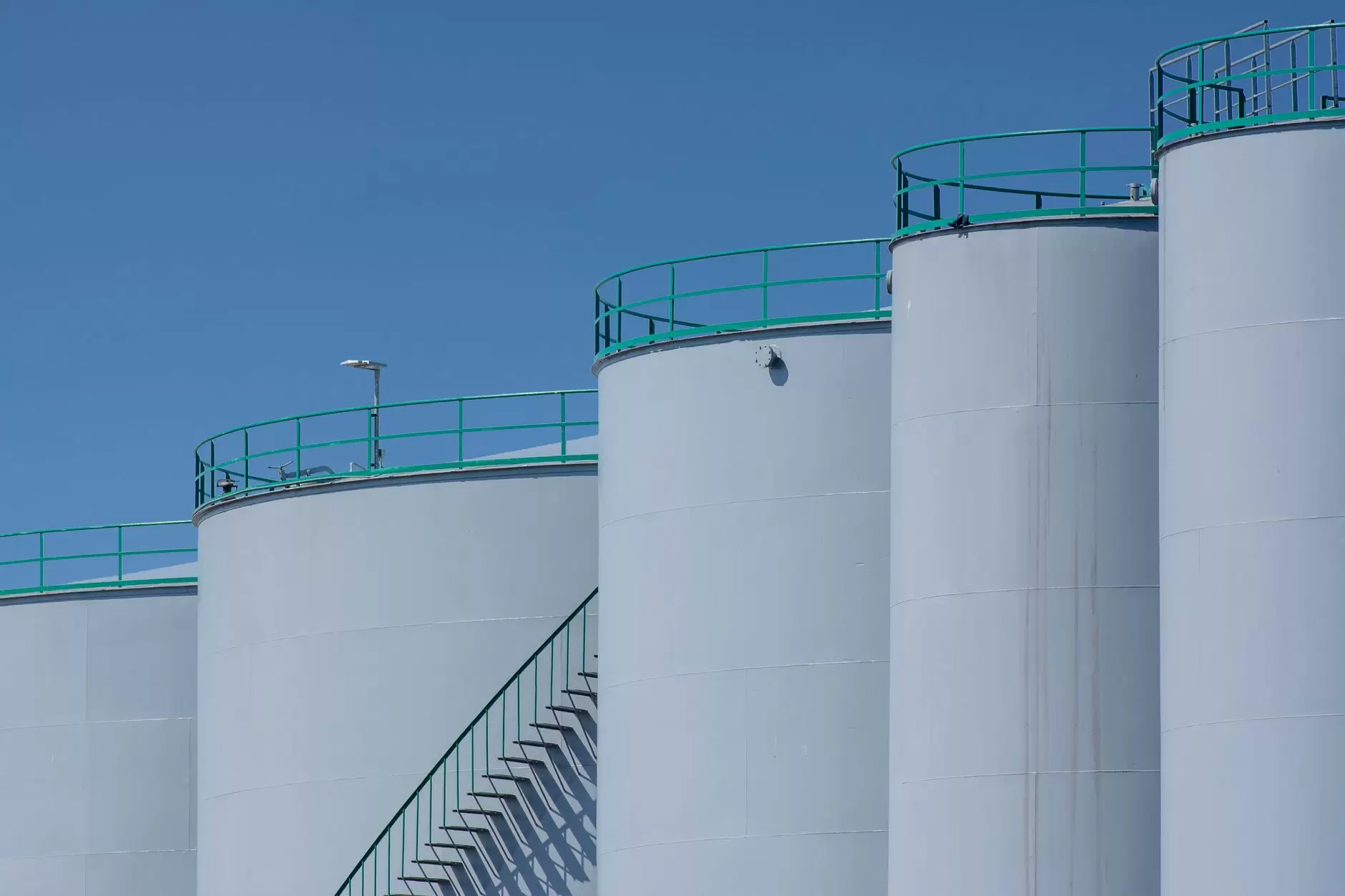 Green Hydrogen in the Energy Transition: Promise, Adoption Challenges, and the Path to Scale — industrial hydrogen storage tanks blue sky