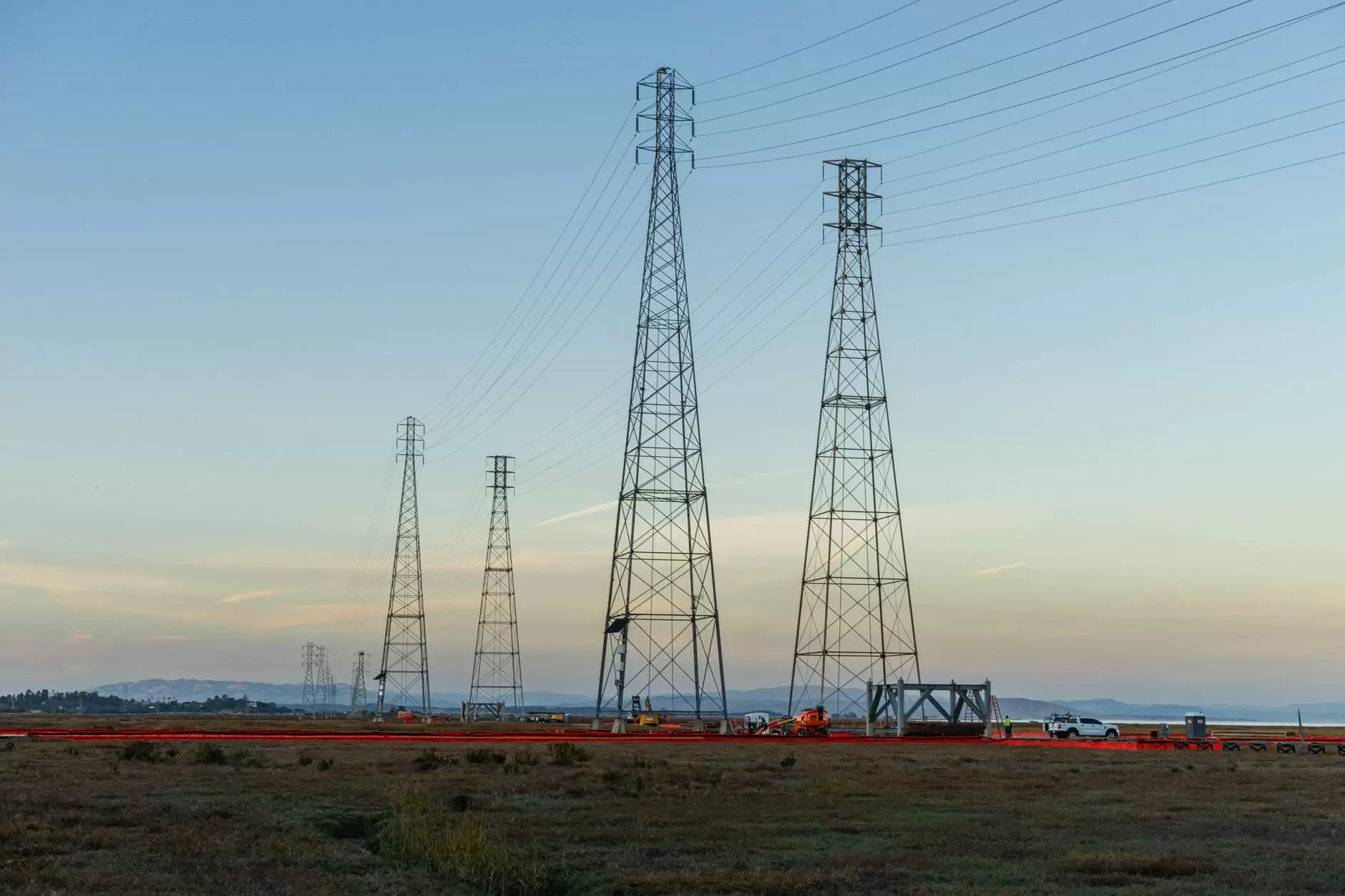 Grid Automation: From Manual Switching to Self-Healing Networks — high-voltage distribution power lines and utility switching equipment at dusk