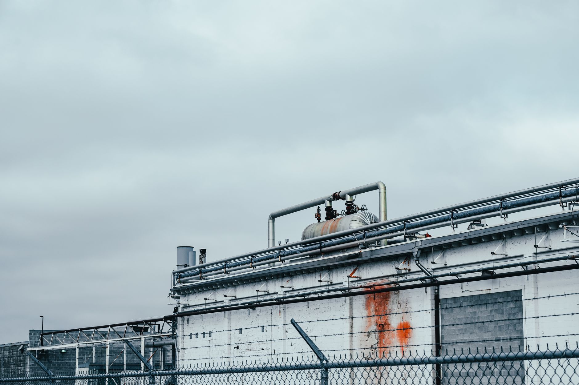 Green Hydrogen in the Energy Transition: Promise, Adoption Challenges, and the Path to Scale — industrial electrolyser facility with pipes and equipment beside solar panels