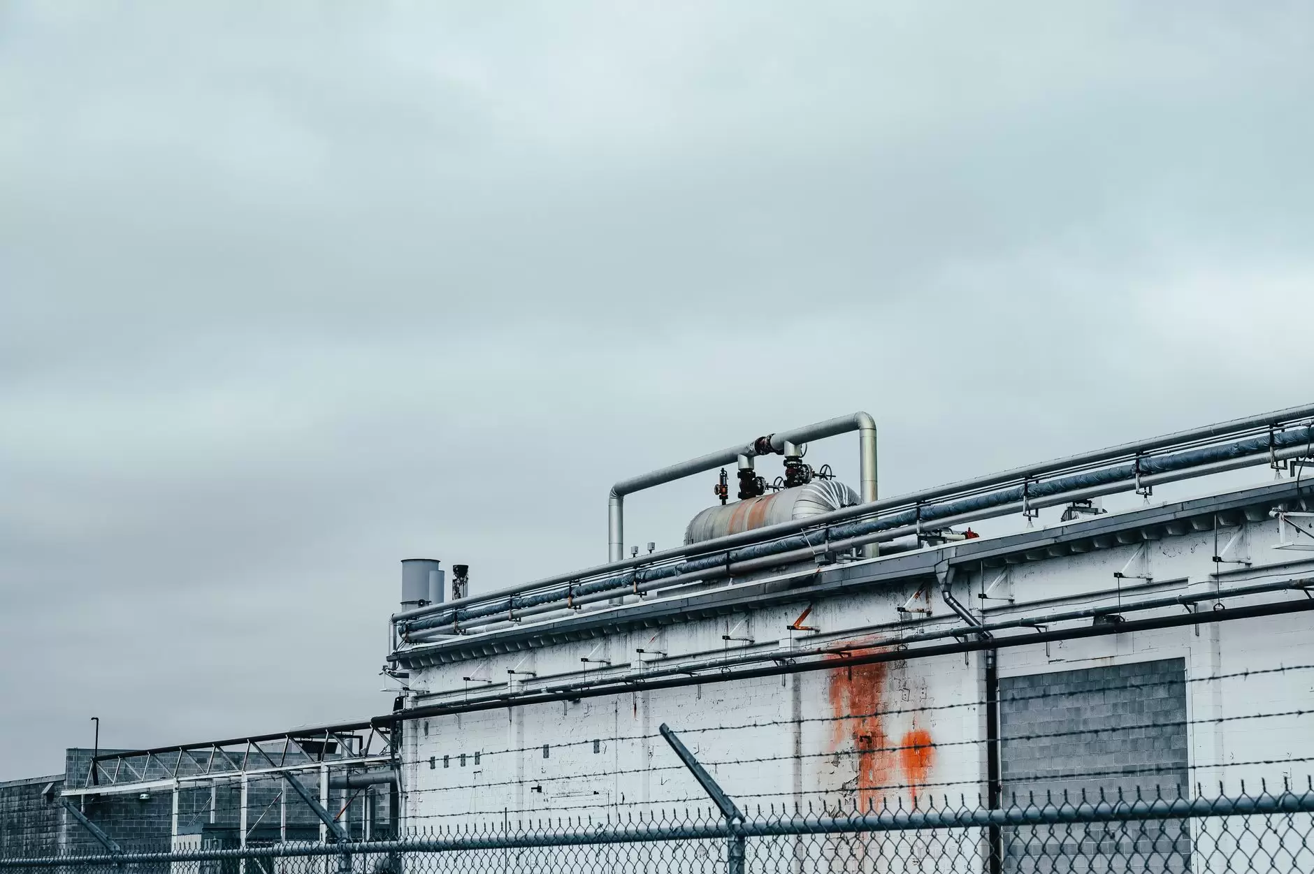 Green Hydrogen in the Energy Transition: Promise, Adoption Challenges, and the Path to Scale — industrial electrolyser facility with pipes and equipment beside solar panels