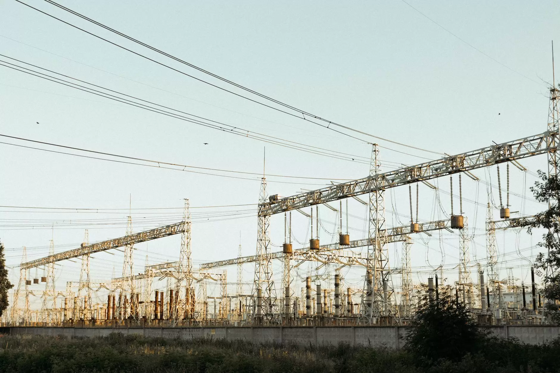 Siting Data Centers: How Electricity Availability and Grid Constraints Shape Location Decisions — high-voltage transmission towers and electrical substation across an open industrial landscape