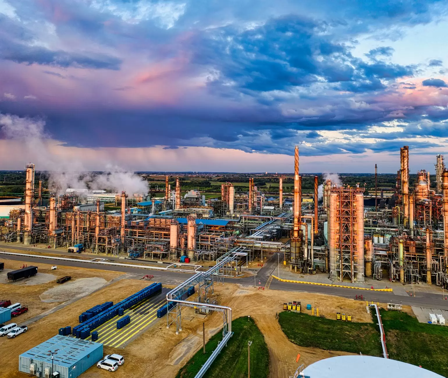Long-Duration Storage Technologies: Comparing Flow Batteries, Iron-Air, and Hydrogen — utility-scale flow battery storage tanks and industrial piping at sunset