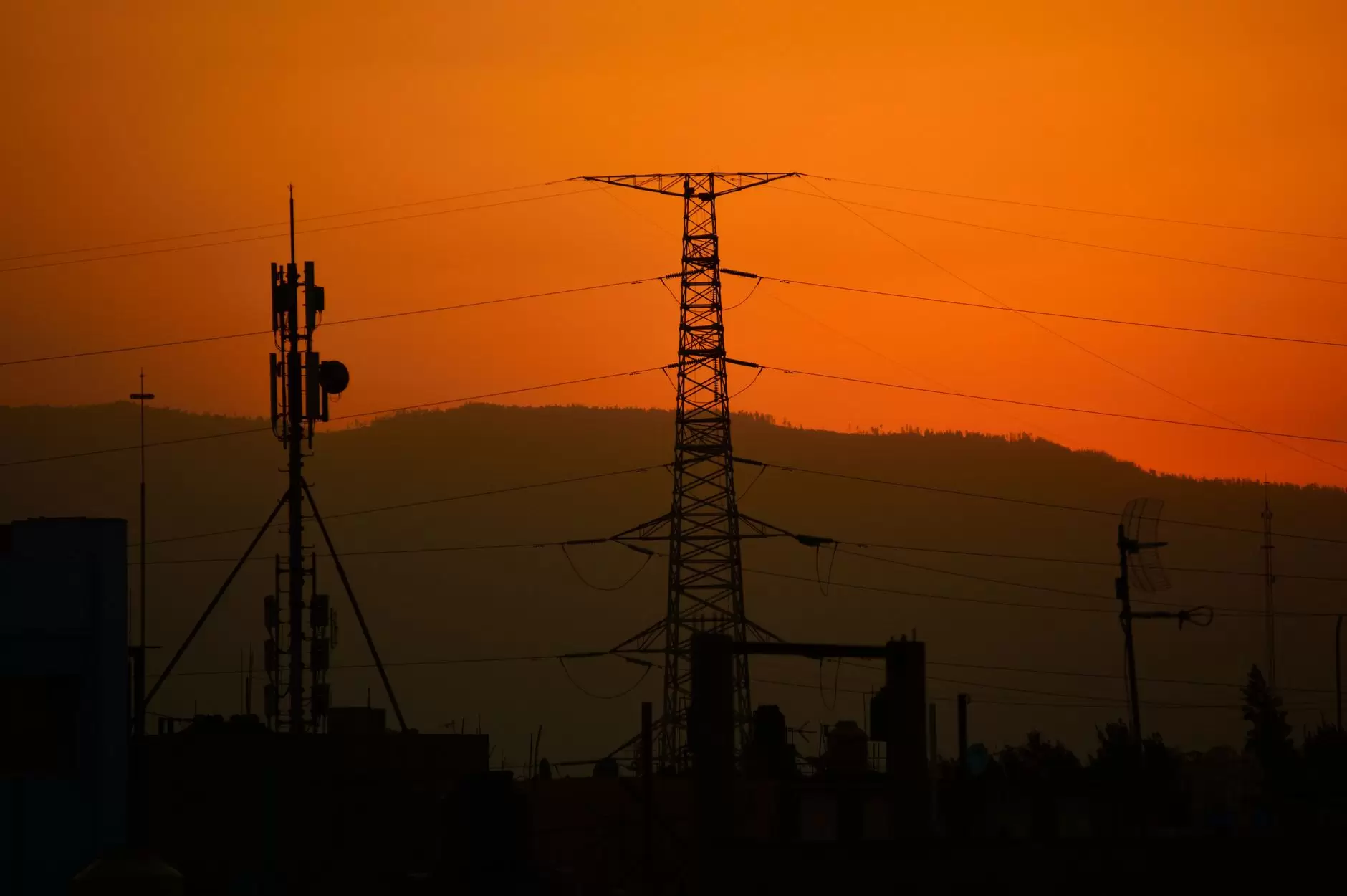 The Economic and Reliability Case for Connecting Southeast Asia's Electricity Systems — high-voltage transmission lines crossing tropical mountain landscape at sunset