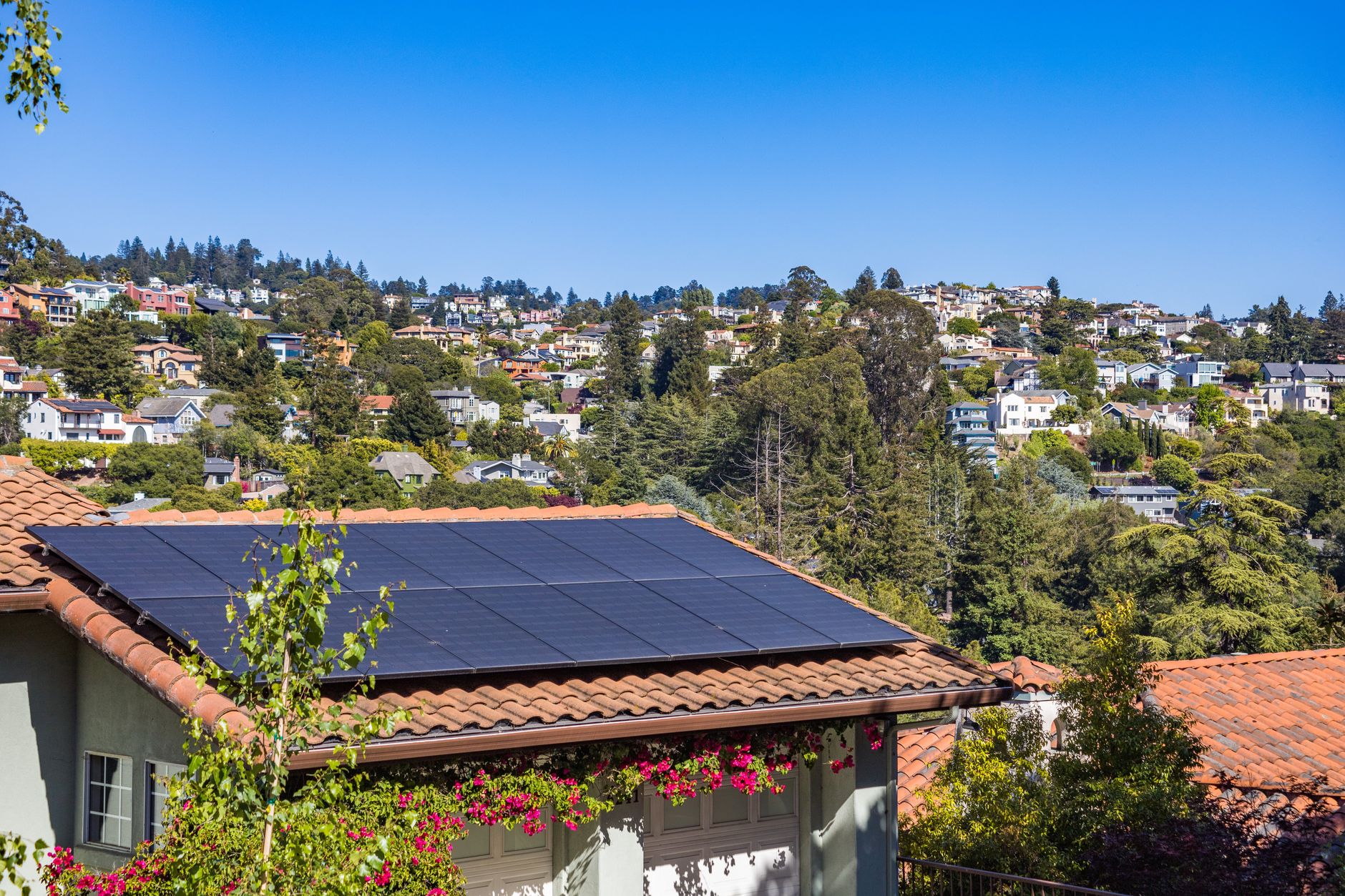 Virtual Power Plants: How Aggregators Turn Distributed Resources into One Grid Asset — rooftop solar panels and residential battery storage on suburban homes