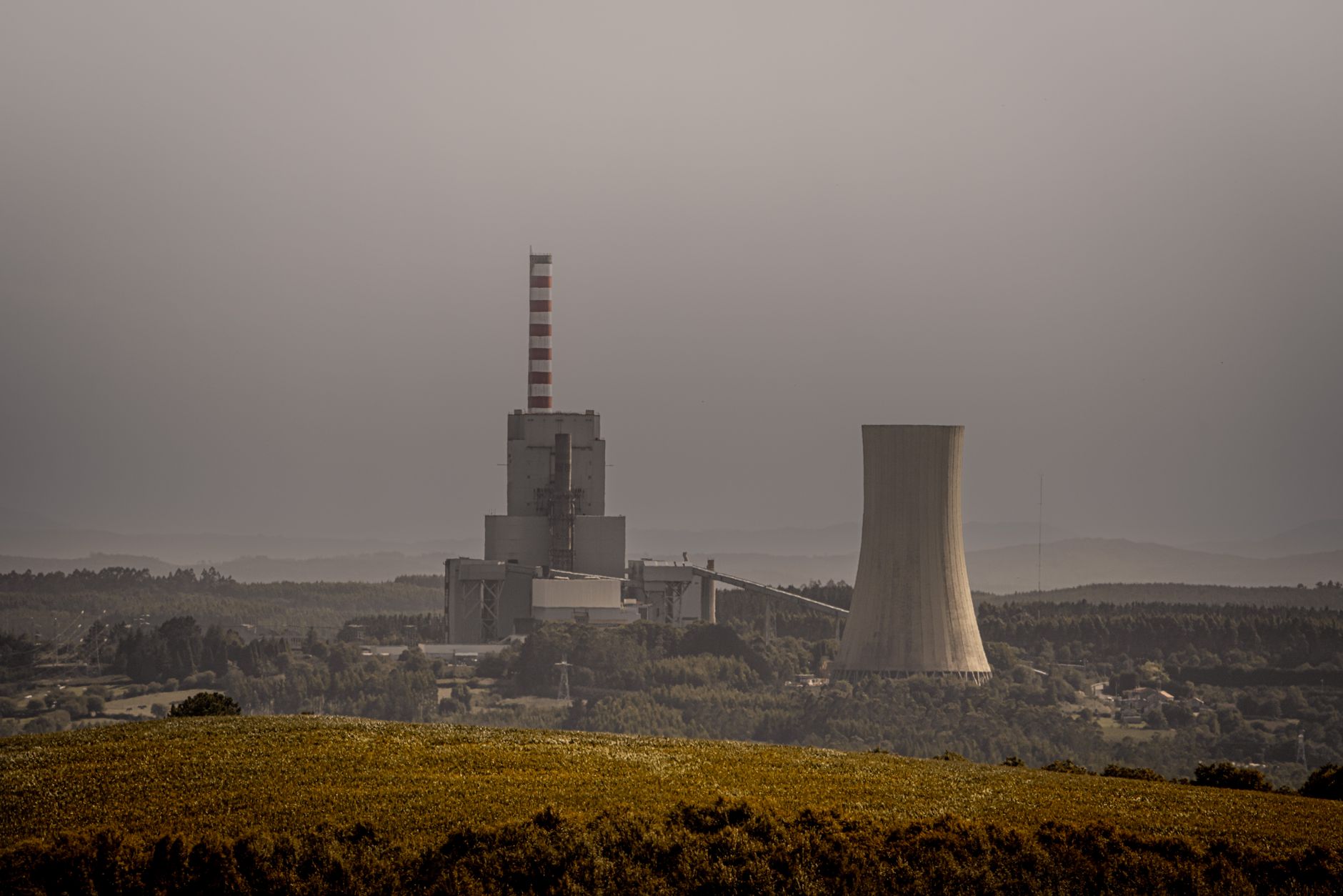 Has India's Coal Peaked? Reading the Emissions Plateau — coal-fired power plant cooling towers and smokestacks under a hazy sky