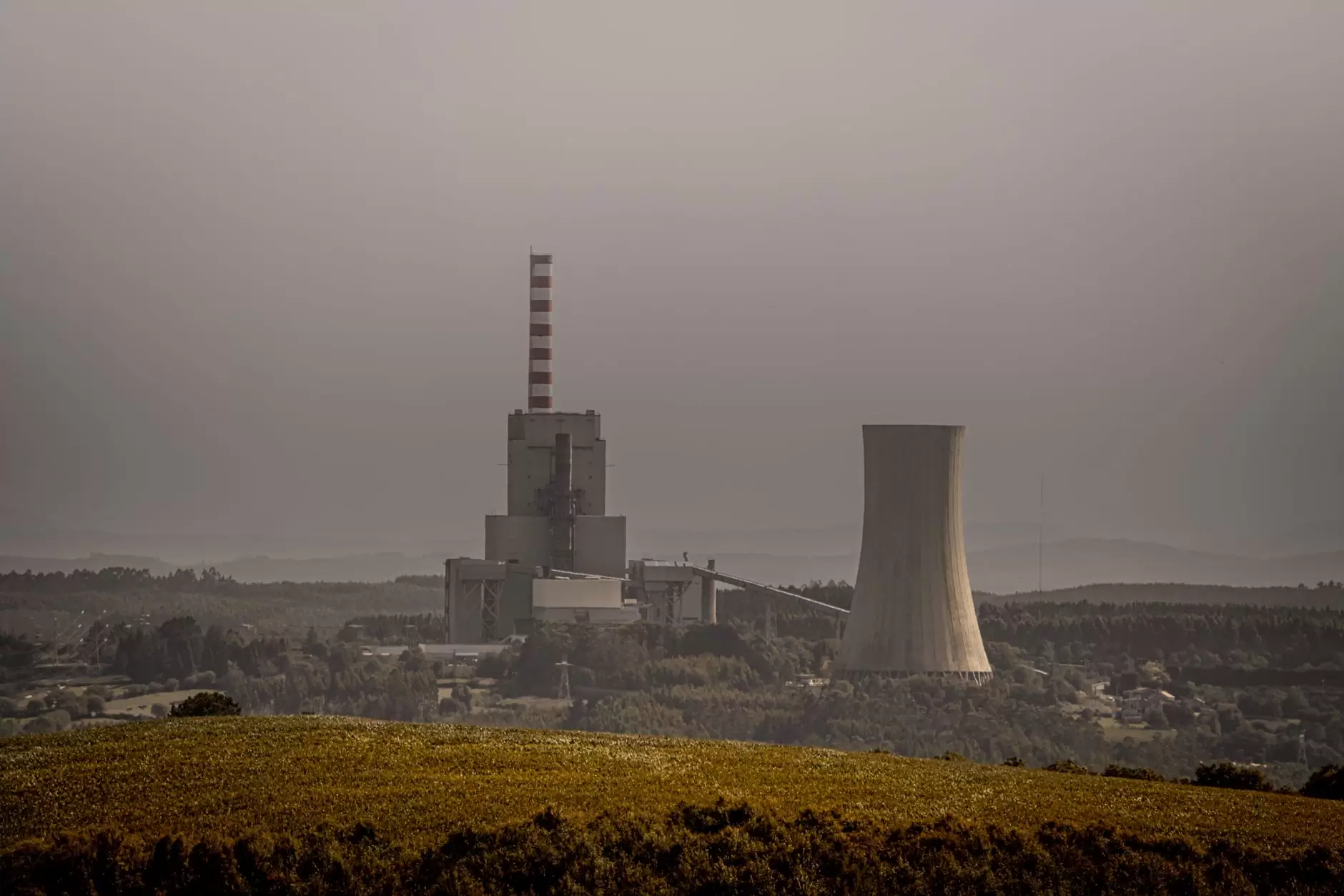 Has India's Coal Peaked? Reading the Emissions Plateau — coal-fired power plant cooling towers and smokestacks under a hazy sky